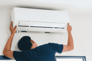 Teknisi sedang memeriksa evaporator AC untuk perawatan rutin