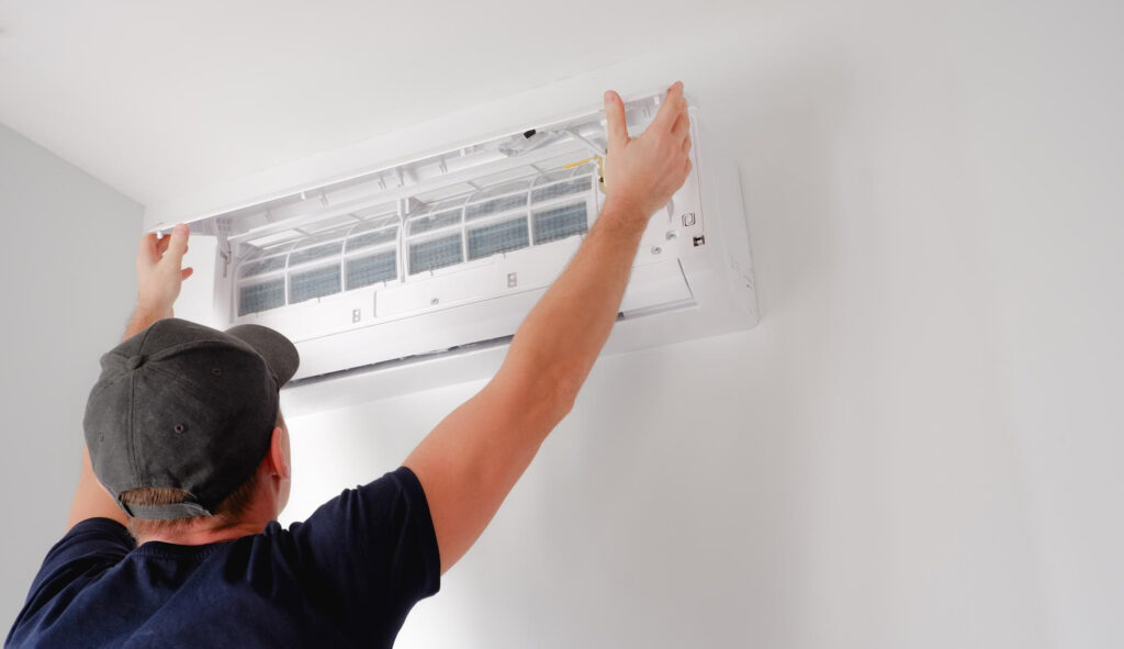 Teknisi sedang membersihkan filter Smart AC untuk menjaga performa pendinginan.