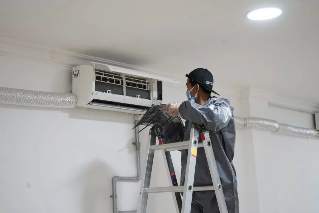 Teknisi sedang memeriksa evaporator AC berisik di dalam rumah Kenapa Evaporator AC Berisik Saat Dinyalakan? Ini Penjelasa