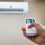 Teknisi sedang menjelaskan cara kerja AC Inverter kepada pemilik rumah