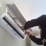 teknisi memeriksa AC inverter di dalam rumah