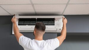 teknisi memeriksa evaporator AC dalam ruangan