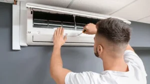 Teknisi sedang memeriksa evaporator AC bocor di dalam rumah
